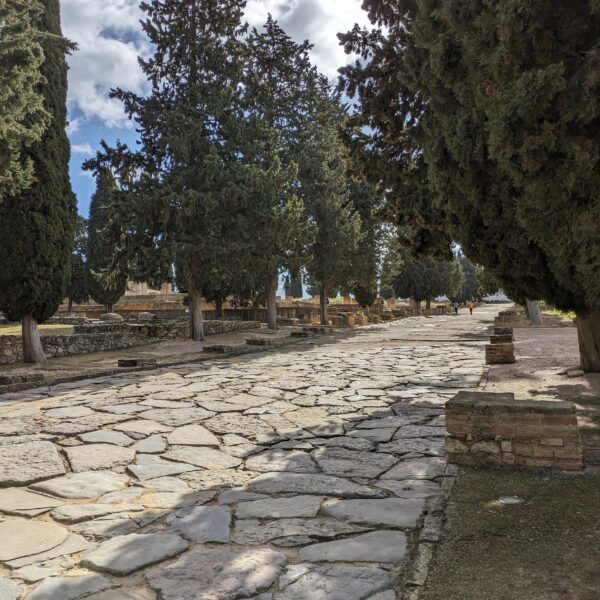 Calle empedrada romana en Itálica visitada durante una excursión educativa escolar