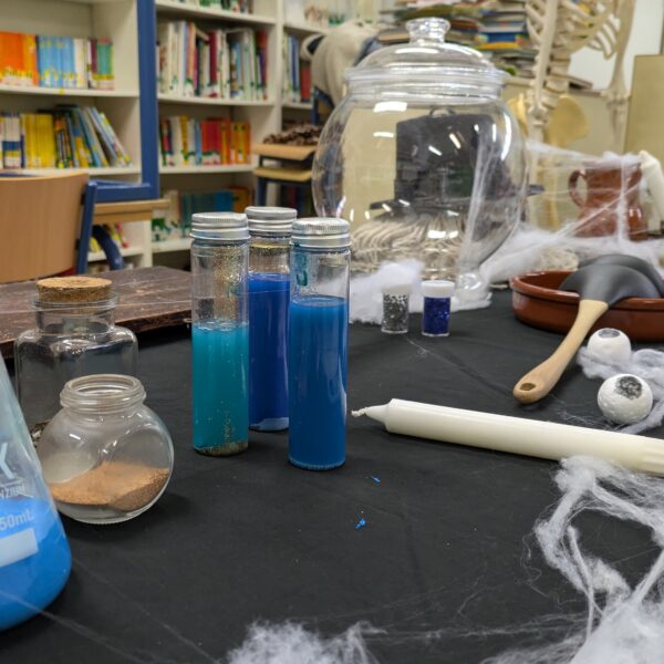 Materiales del taller “Malvados de Cuentos” con frascos, probetas y elementos decorativos de laboratorio mágico.