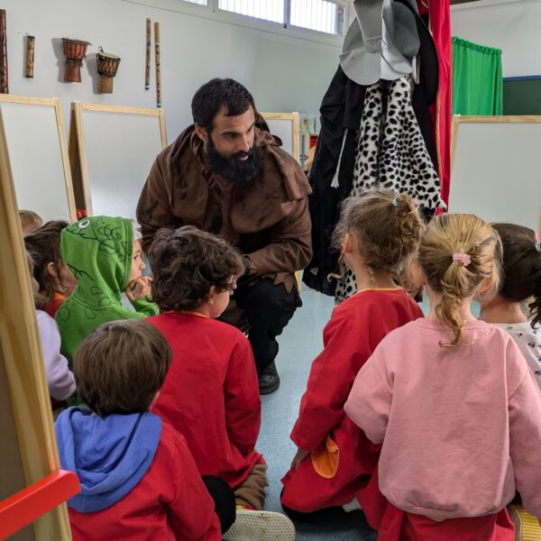 Educador disfrazado de personaje malvado conversa con un grupo de niños en el aula durante el taller “Malvados de Cuentos”.